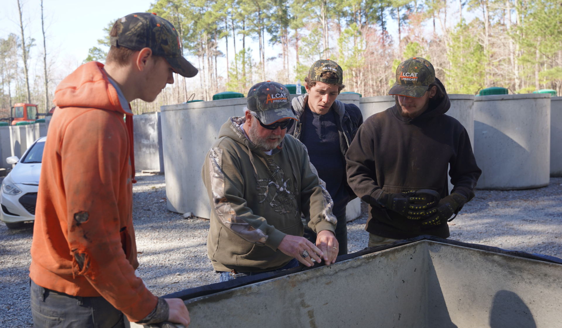 allen showing his employees how to work on the concrete tank