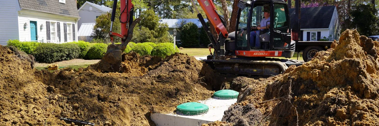 employee operating tractor to bury newly installed septic tank system